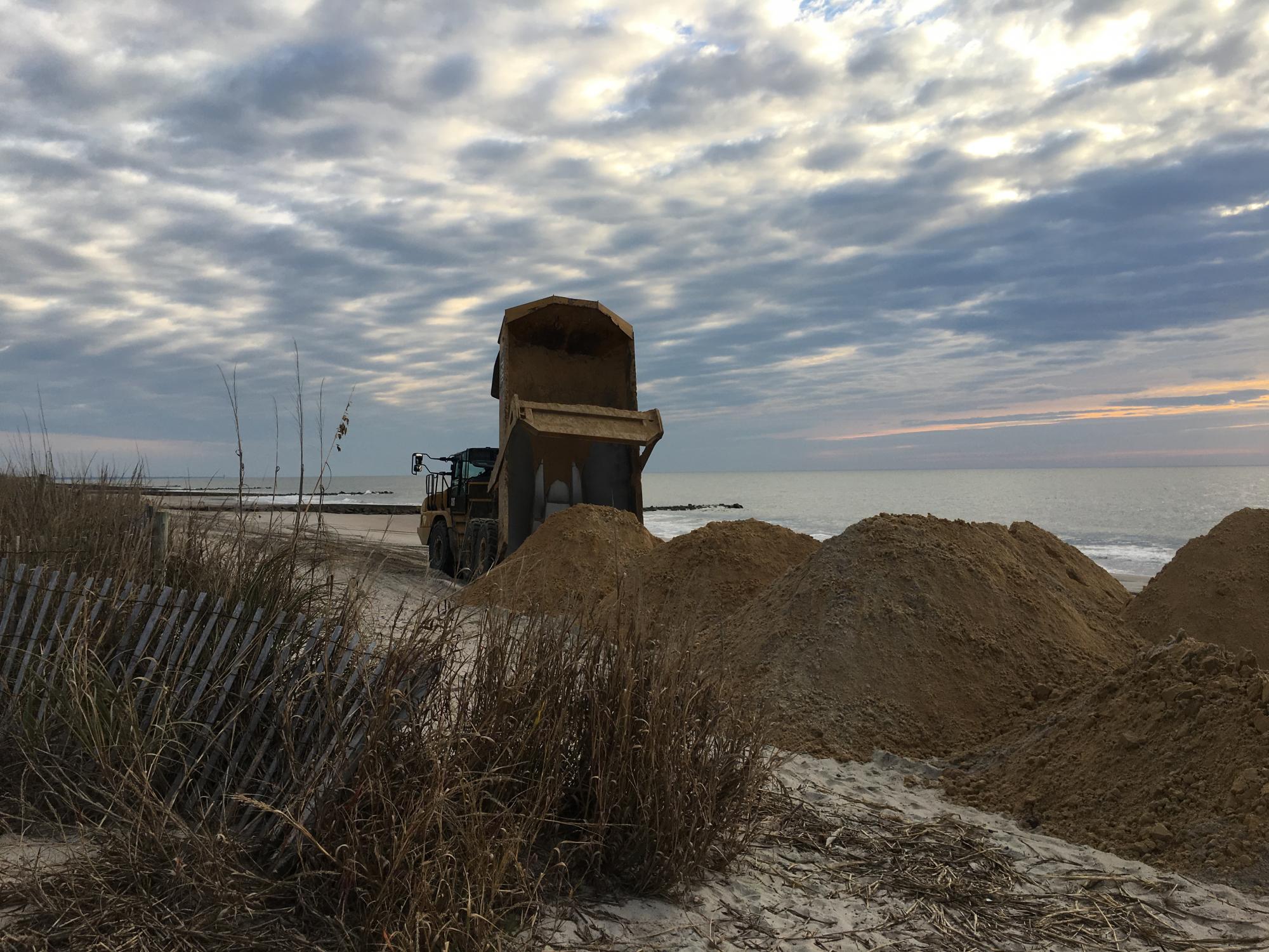 Dump Truck placing sand on beach